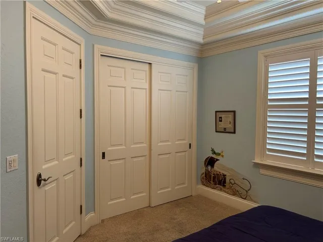Bedroom 2 with Closet entrance, crown molding, and detailed ceiling.