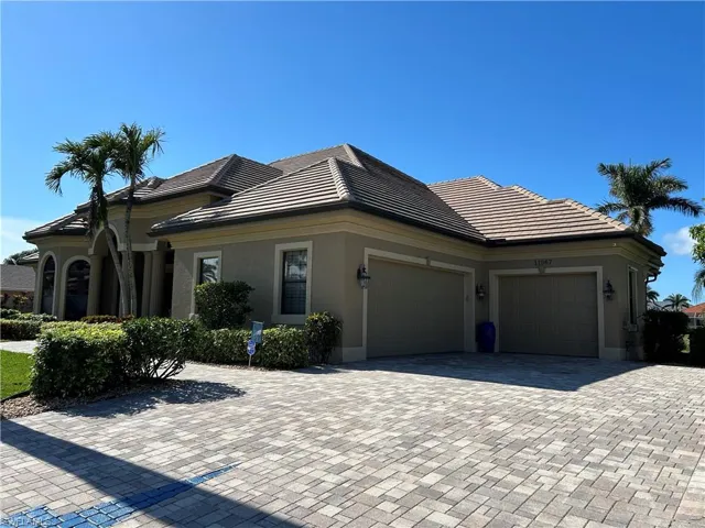 Front view from the right side showing the paver driveway to the 3-car garage and walkway to front entrance.