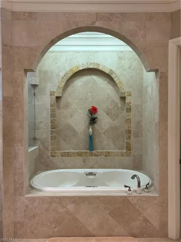 Master Bath featuring Jetted Tub, Beautiful Tile Detail, and crown molding.