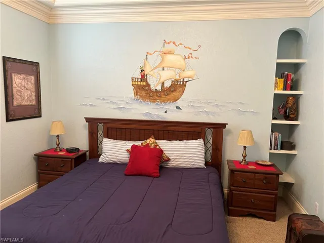 Bedroom 2 featuring Built-in shelving and tray ceiling with crown molding.