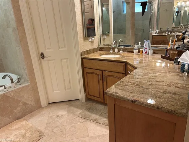 Master Bath featuring 2 separate vanities each with wood cabinets and Granite top, this one the right side and an enclosed shower, separate entrance for toilet and Jetted Tub.