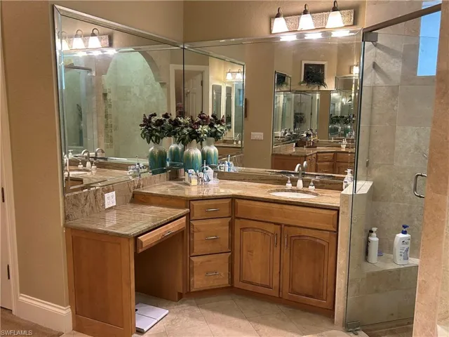 Master Bath featuring 2 separate vanities each with wood cabinets and Granite top, this one the left side and an enclosed shower, separate entrance for the toilet and Jetted Tub.