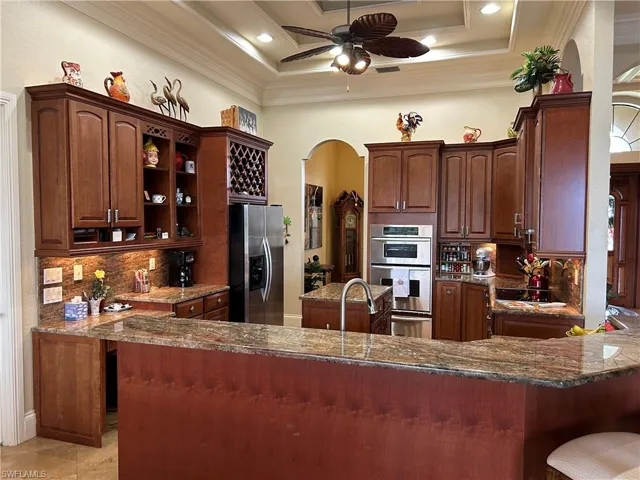 Kitchen with Granite Countertops, 48" Wood Cabinets, Island, Stainless Appl and under Cab lighting and tray ceiling with Crown Molding.