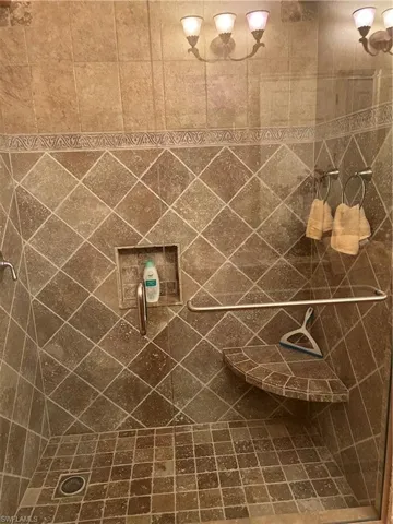 Bathroom 2 featuring walk in shower with built -in chair.