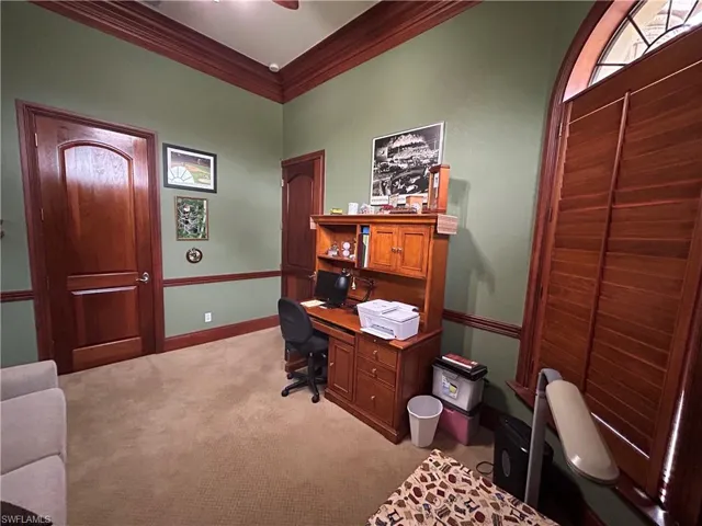 Office with Beautiful wood doors, wood plantation shutters, wood crown molding, closet, wood baseboard and wood chair rail.