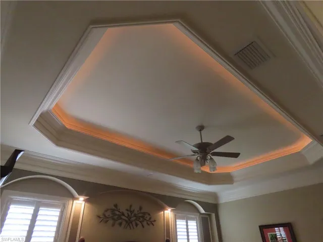 Master BR with crown and lighted tray ceiling, ceiling fan, and plantation shutters.