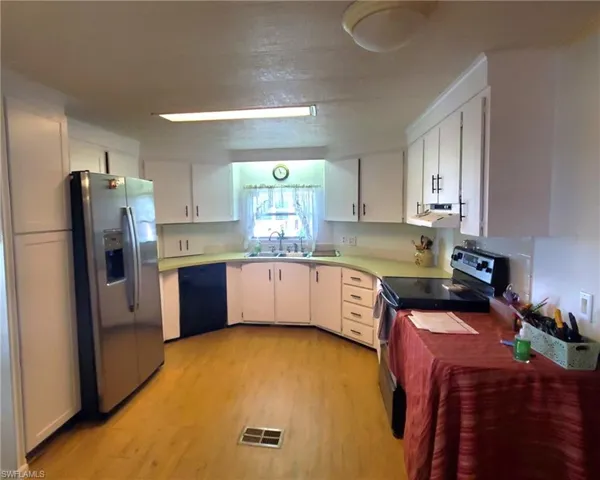 Kitchen with pantry, fridge w/icemaker, dishwasher, and smooth-top stove.