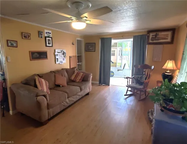 Spacious living room with laminate floor and ceiling fan.