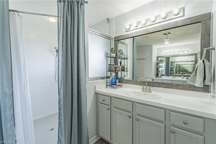 Bathroom featuring a shower with curtain and vanity
