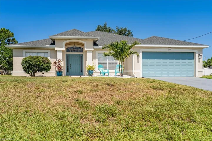 View of front of home featuring a front yard and a garage