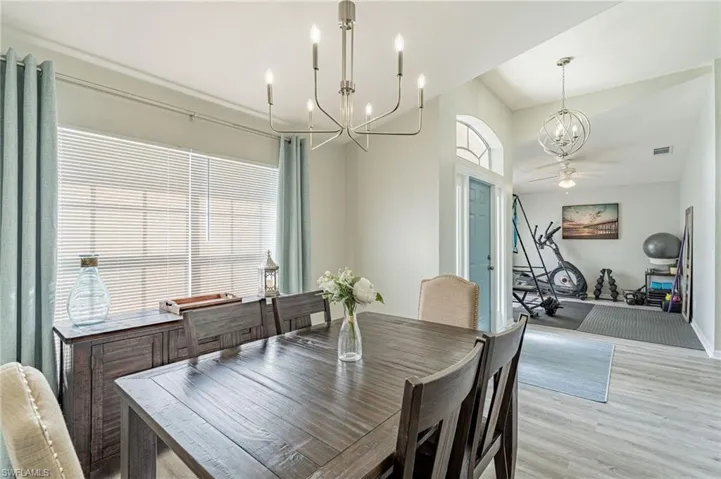 Dining area featuring a wealth of natural light, wood-type flooring, and ceiling fan with notable chandelier