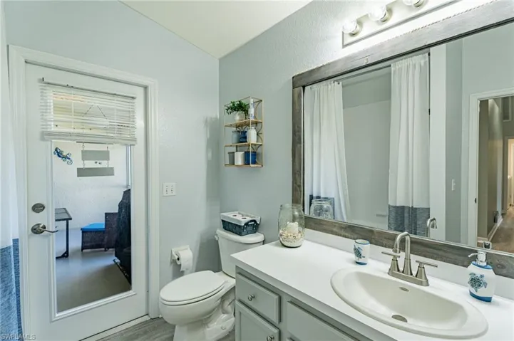 Bathroom with vanity with extensive cabinet space and toilet