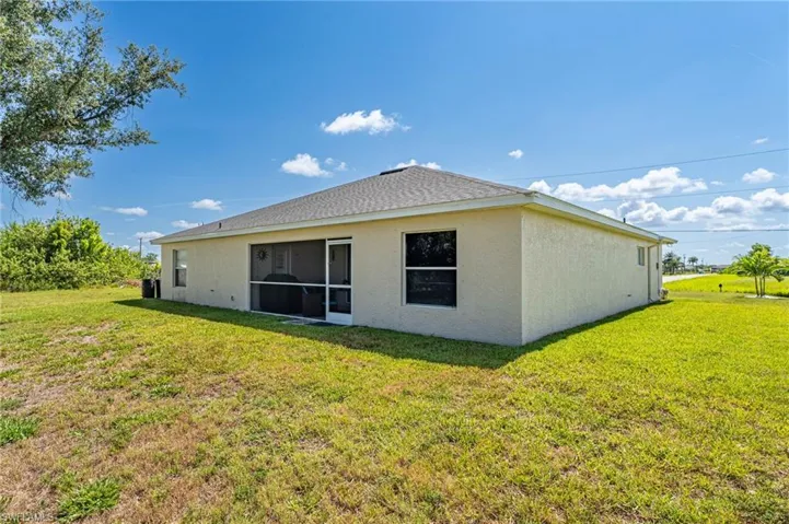 Back of house with a yard