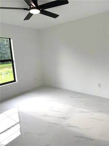 Spare room featuring baseboards and ceiling fan