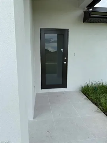 Property entrance with stucco siding and a patio area