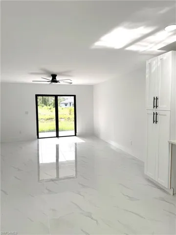Unfurnished room with light marble finish flooring and a ceiling fan