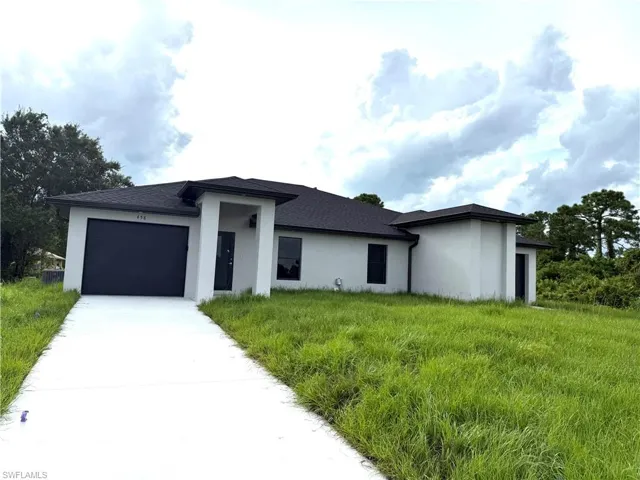 Prairie-style home with an attached garage, driveway, and stucco siding