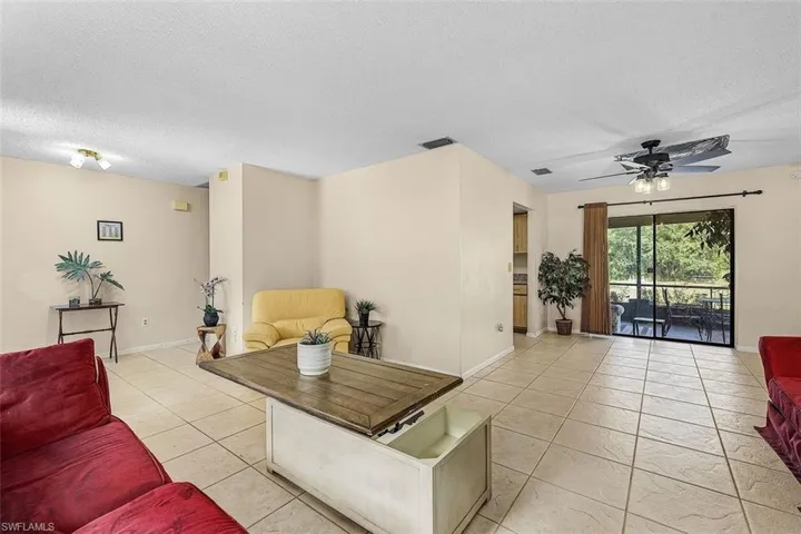Tiled living room with a textured ceiling and ceiling fan