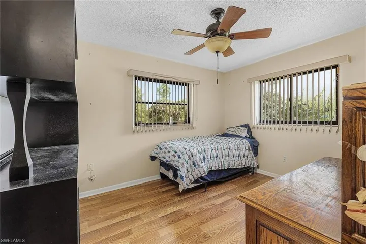 Bedroom featuring light wood-type flooring, ceiling fan, and a textured ceiling