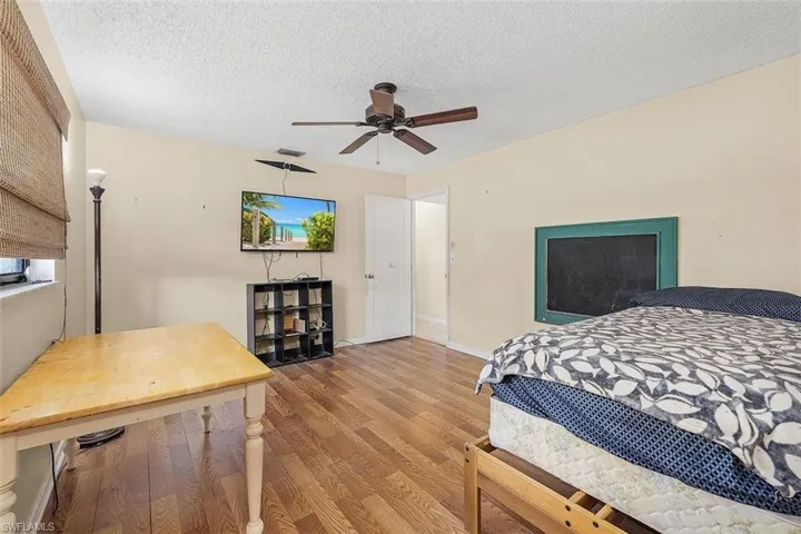 Bedroom featuring a textured ceiling, ceiling fan, and light hardwood / wood-style floors