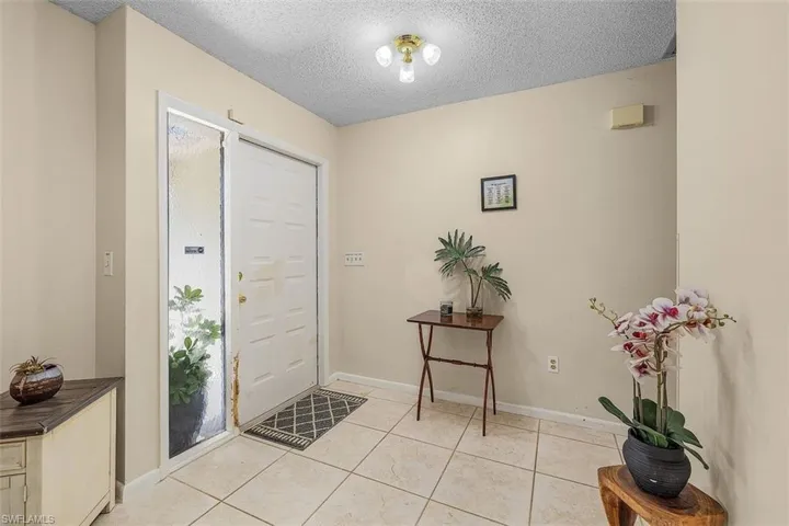 Tiled entryway with a textured ceiling