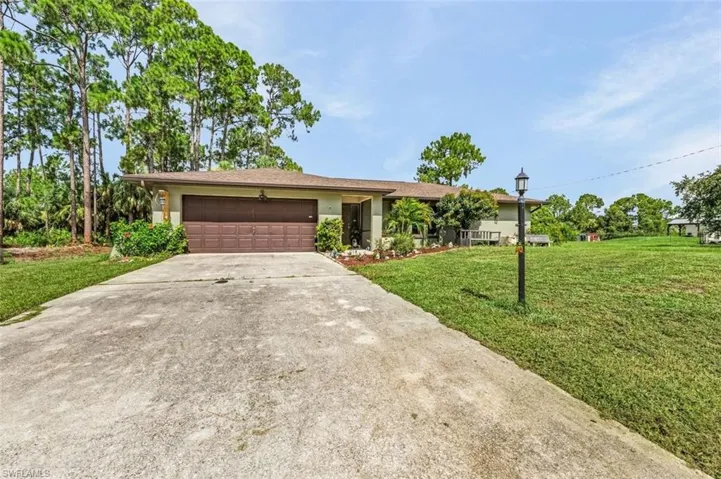 Single story home featuring a garage and a front yard