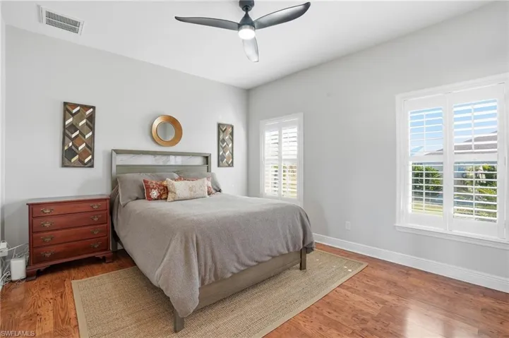 Bedroom featuring a ceiling fan and wood finished floors - Virtually Edited