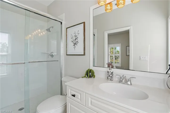 Full bathroom featuring a stall  - Virtually Editedshower, vanity, and a chandelier