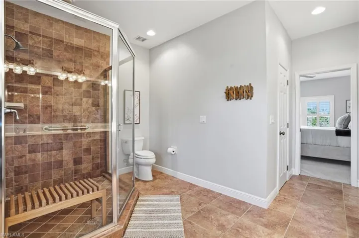 Ensuite bathroom featuring a shower stall and recessed lighting - Virtually Edited