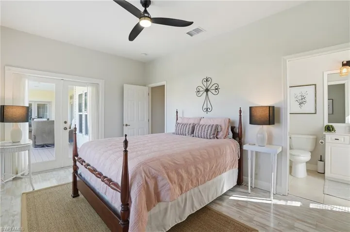 Bedroom with light wood finished floors, a ceiling fan, french doors, and access to outside - Virtually Edited