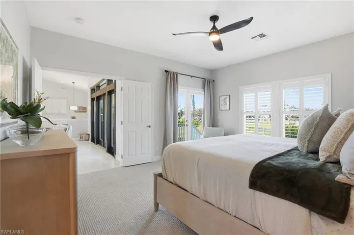 Bedroom with access to outside, ceiling fan, and light carpet - Virtually Edited