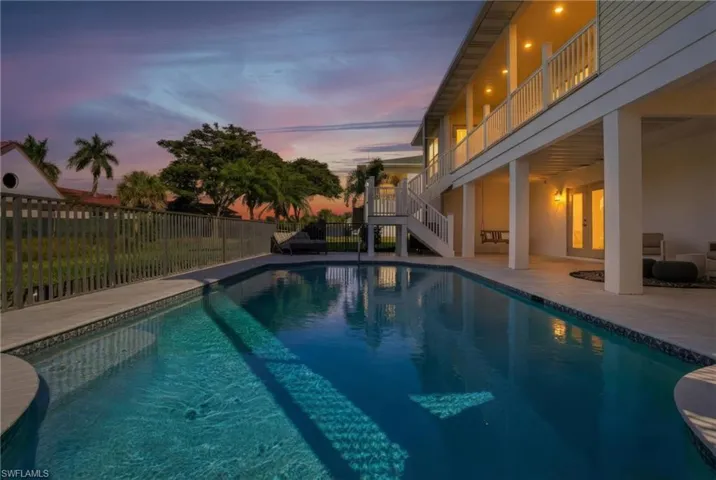 View of swimming pool with patio, stairs, and a balcony - Virtually Edited