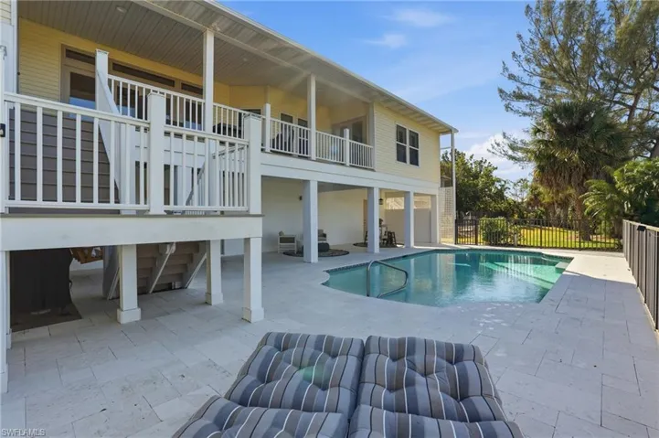 View of pool featuring a patio, stairway, and a balcony - Virtually Edited