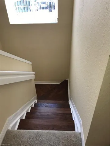 Stairway featuring a textured wall