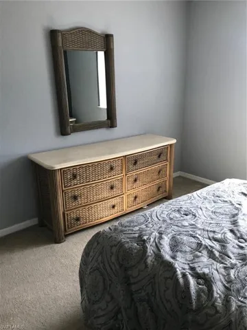 Bedroom with light colored carpet and baseboards