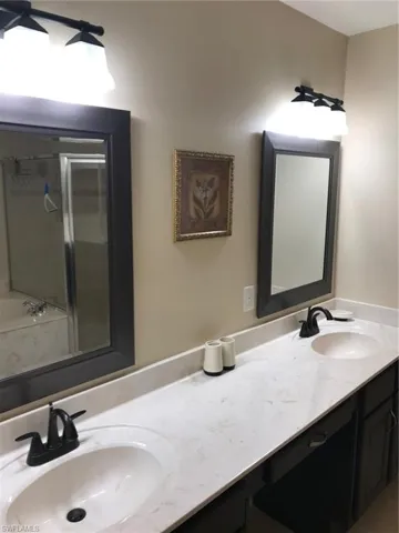 Full bath featuring double vanity, a stall shower, and a bath