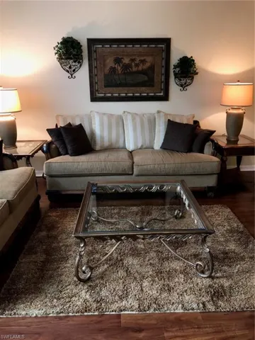Living room with dark wood-style flooring and baseboards