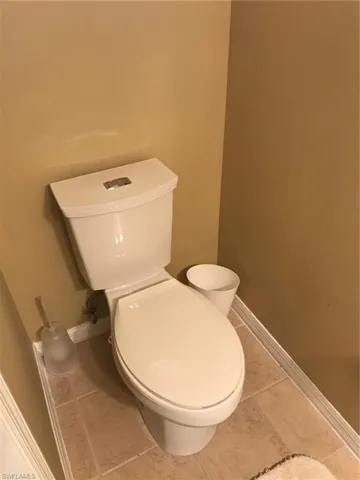 Bathroom with toilet and light tile patterned flooring