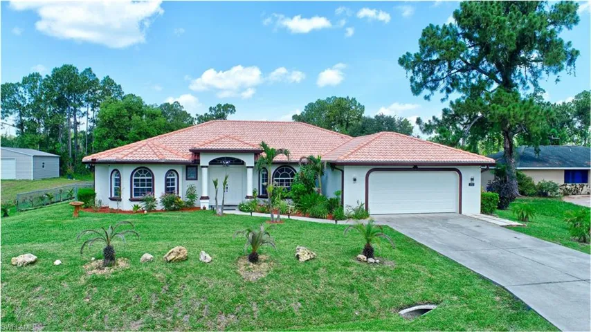 Mediterranean / spanish house featuring a garage and a front lawn