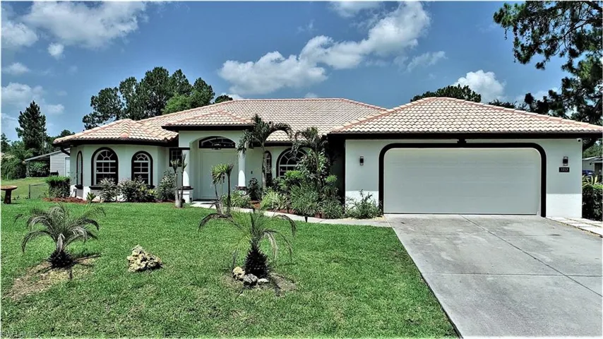 Mediterranean / spanish house with a front yard and a garage