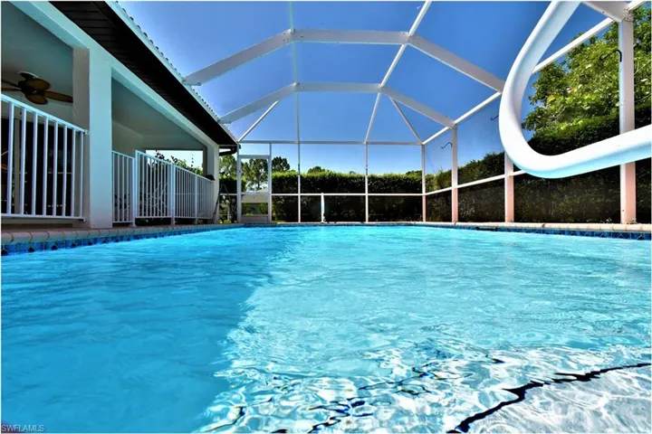 View of pool featuring a water slide, ceiling fan, and a lanai