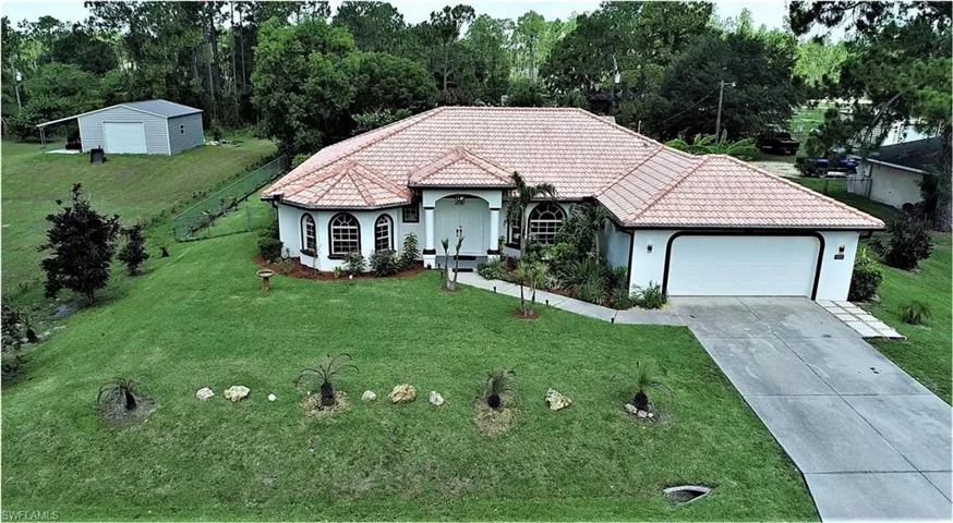 View of front facade featuring a garage and a front lawn