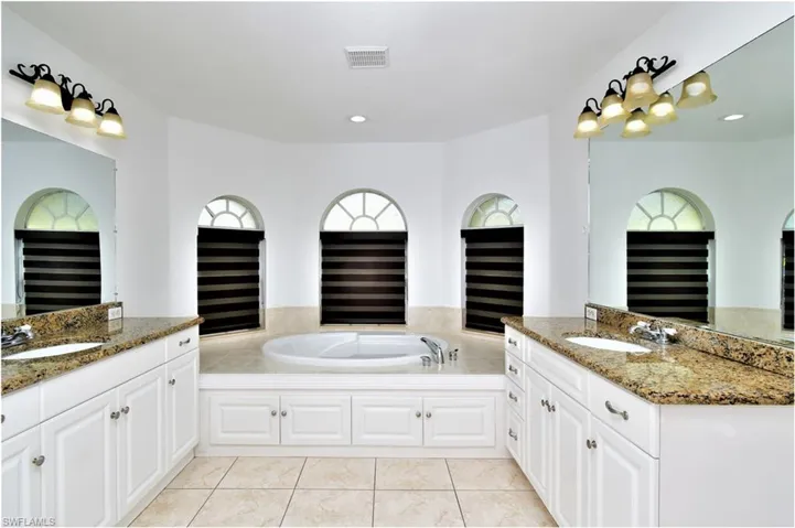 Bathroom with vanity, tile patterned floors, and a bathtub