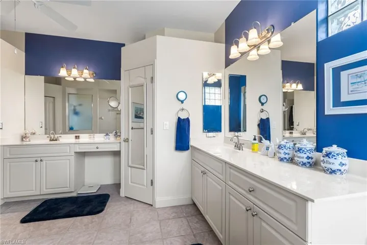Bathroom featuring a sink, two vanities, a ceiling fan, and tile patterned floors