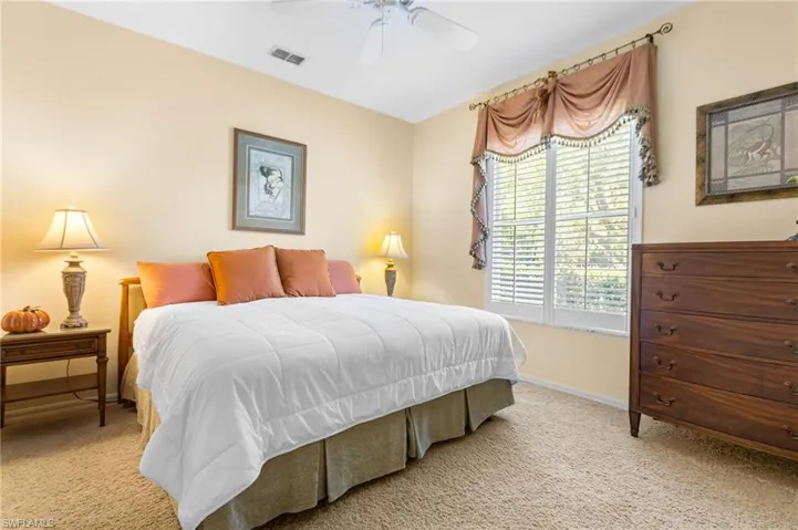 Carpeted bedroom with baseboards and a ceiling fan