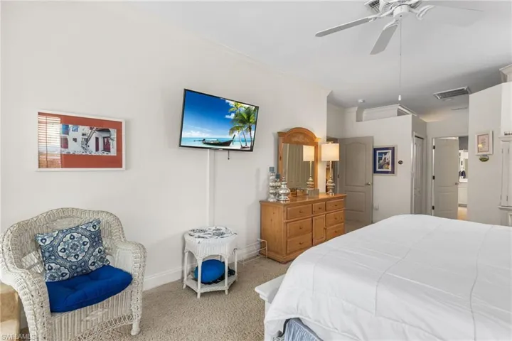 Carpeted bedroom featuring ceiling fan, baseboards, visible vents, and ornamental molding