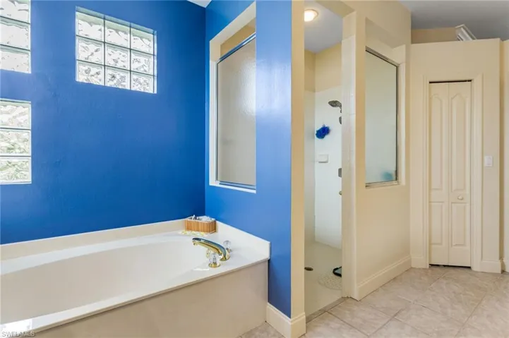 Bathroom featuring a shower stall, a bath, and tile patterned floors