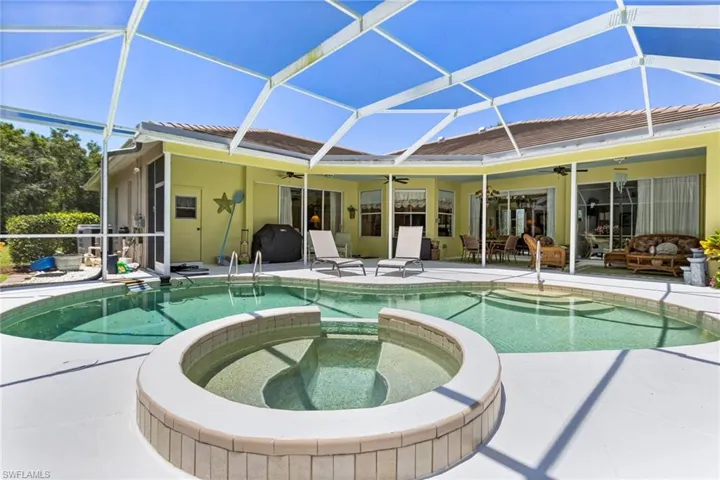 View of pool featuring a ceiling fan, a pool with connected hot tub, a patio, and a lanai