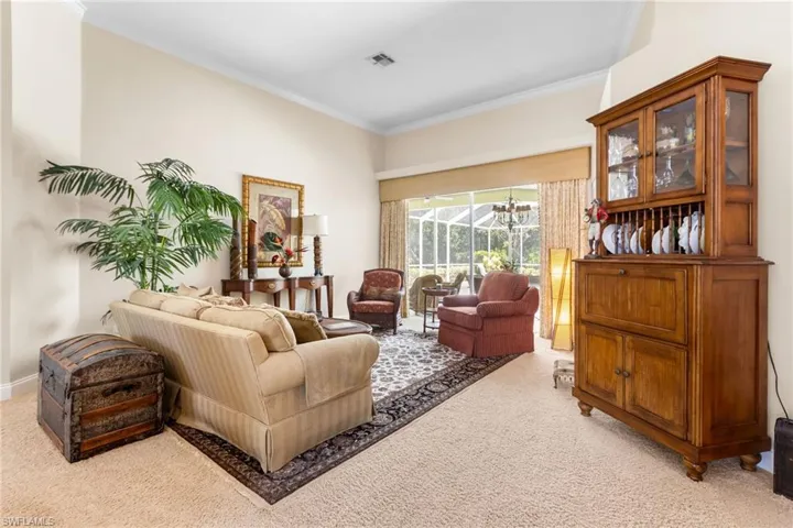Living room featuring light carpet and ornamental molding