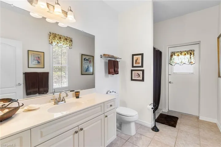 Full bathroom with plenty of natural light, toilet, vanity, and tile patterned flooring